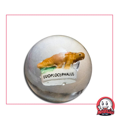 Bille en verre 35 mm avec incrustation de dinosaure Euoplocephalus, détail réaliste et base blanche.