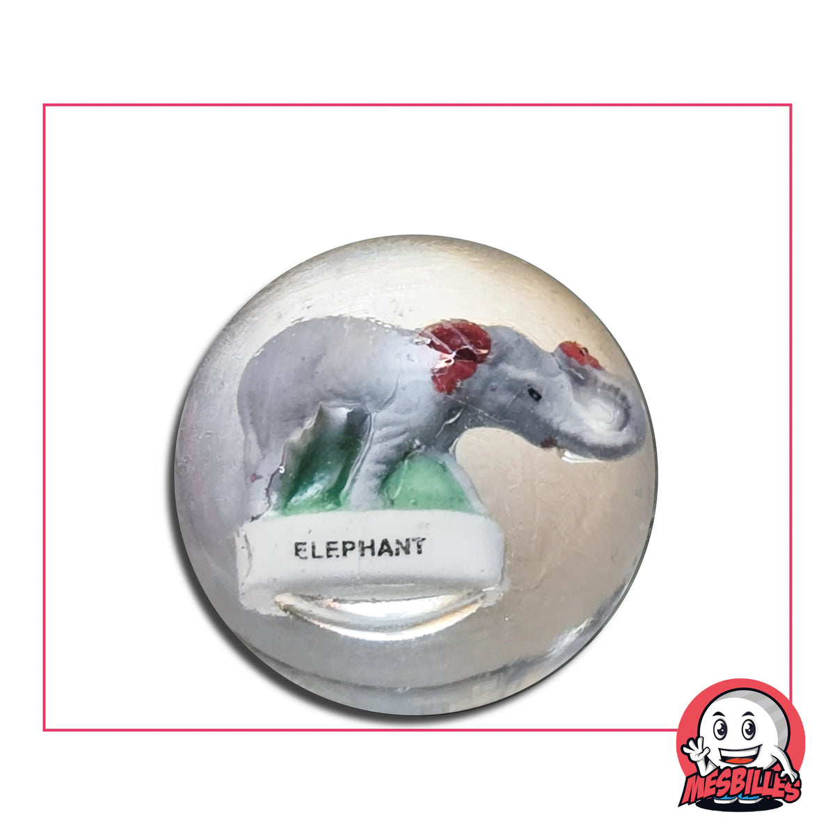Au centre de cette bille en verre de 35 mm, un éléphant en porcelaine se dresse avec sagesse et prestance, semblant traverser le temps dans son écrin translucide.
